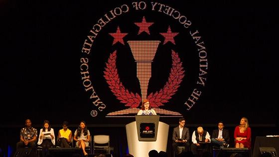 满帆的全国大学学者协会分会成员在NSCS仪式的舞台上.