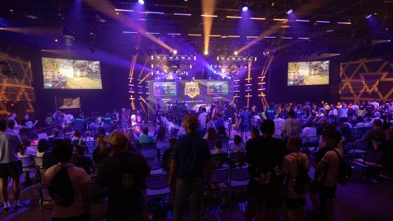 观看电子竞技比赛的一大群人, 房间前面的一个大LED屏幕上写着“北美总决赛”.’