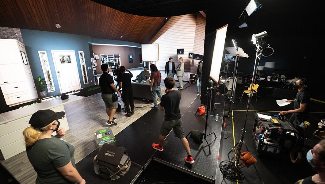 工作人员设置摄像机，并在场景之间对虚拟客厅背景进行调整.